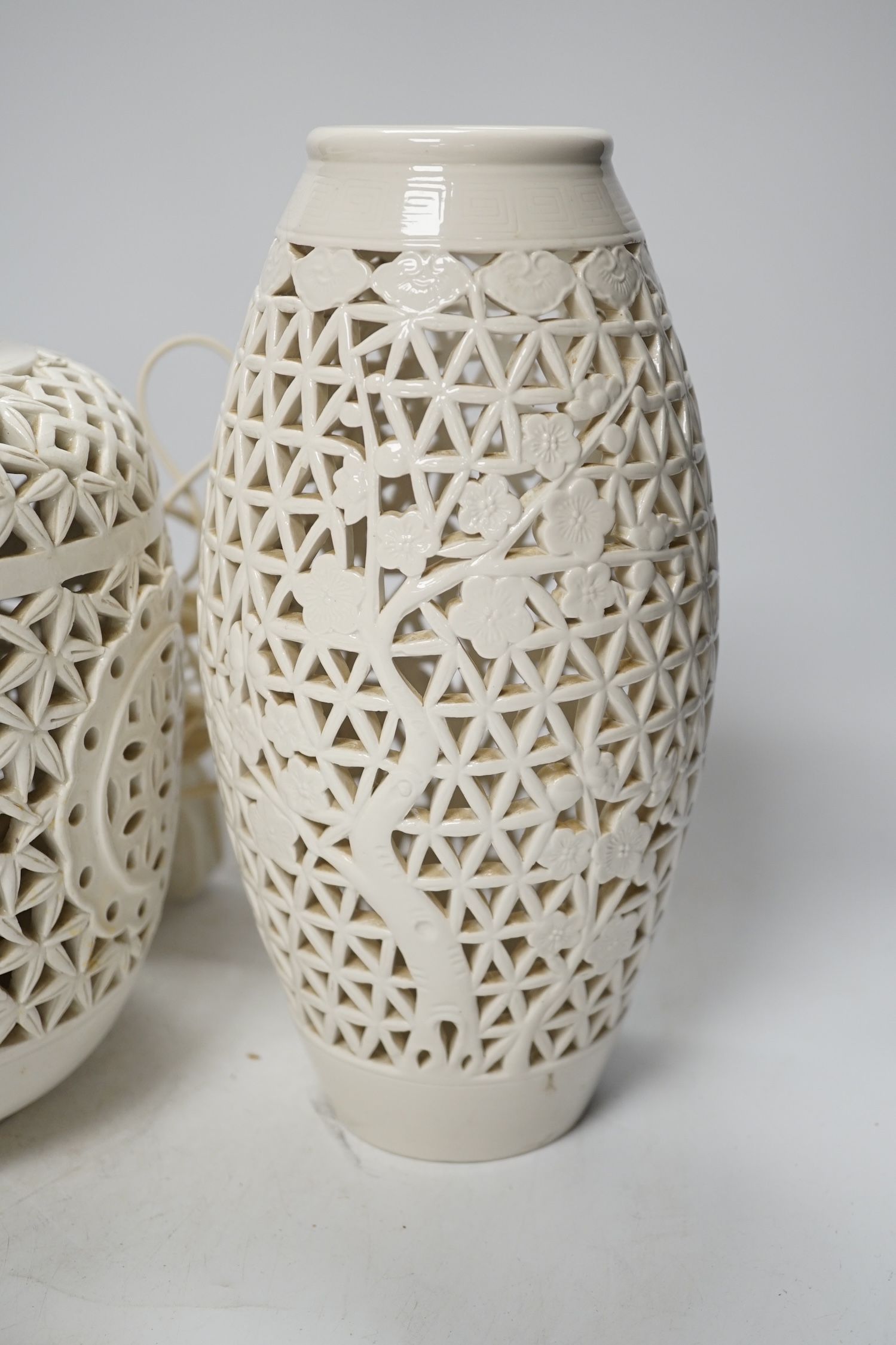 A Chinese pierced white glazed ceramic table lamp and two similar vases, tallest 27cm. Condition - fair